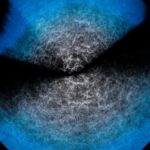 Die beiden Fächer im Bild sind Bereiche des Universums, die das DESI-Spektroskop (Kitts Peak National Observatory) ober- und unterhalb der Ebene unserer Milchstraße beobachtet hat. Die Erde liegt im Zentrum der beiden Fächer, wobei bläulichere Punkte weiter entfernte Objekte anzeigen.